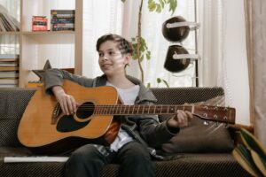 Man in Black Long Sleeve Shirt Playing Acoustic Guitar